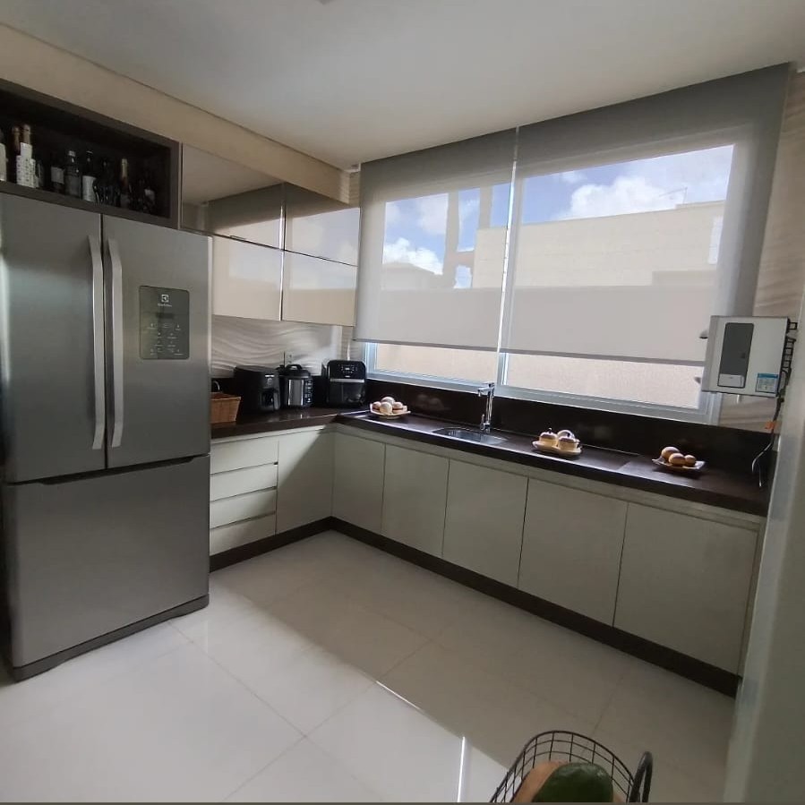 Cozinha planejada com armários claros e bancada em granito